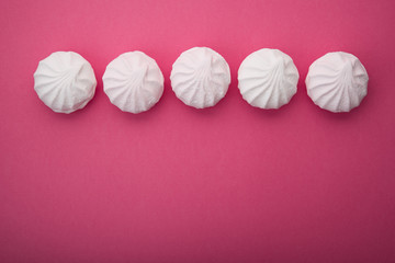Tasty sweet zephyr on pastel pink background.