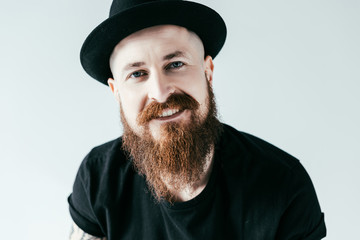 smiling handsome bearded man looking at camera isolated on white