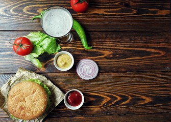  гамбургер проткнутый ножом на газете с пивом