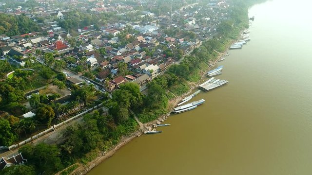 4k Video shot aerial view by drone. Historic Luang Prabang on the Mekong River in Laos. Road in the city. Home village streets.