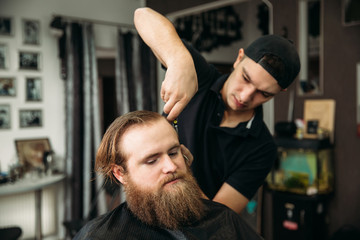 Fototapeta na wymiar Male client getting haircut by hairdresser
