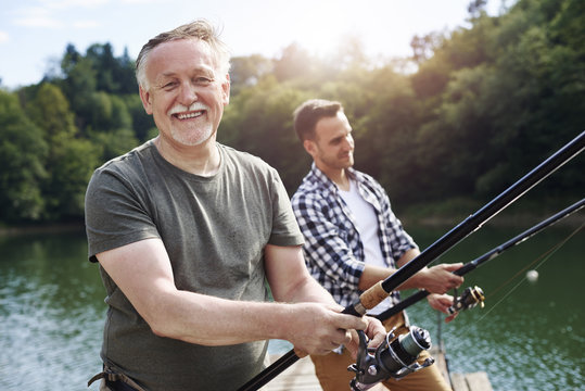 Portrait of cheerful senior man fishing .