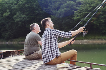 Son and father catching of fish.
