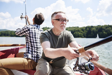 Obraz premium Male friendship with fishing rod on the rowboat