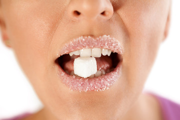 Fototapeta premium Female lips with sugar biting cube