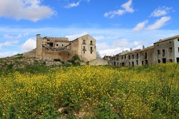 altes verfallenes haus in der landschaft südspaniens/ruine in mitten eines gelben blumenfeldes unter blauem himmel/steinmauern, überreste einer längst vergangenen zeit
