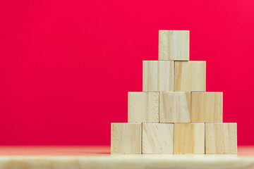 stack of wood cube building blocks on red background