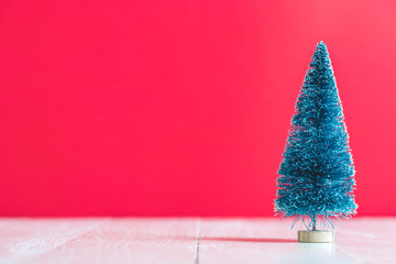 green  artificial pine tree on red background