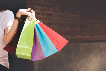 Closeup of woman holding shopping colorful of shopping bags on the street with copy space -...