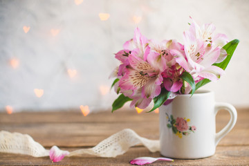 bouquet of flowers in a white mug with a white ribbon