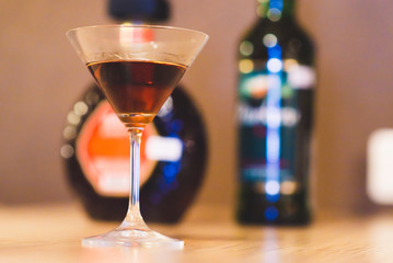 glass of liquor on the background of bottles
