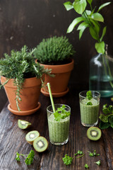 Green smoothies in glass glasses on wooden table
