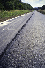 A new road under construction being surfaced with tarmac