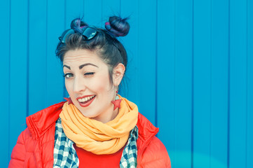 Young beautiful fashion hipster woman with colorful hair winking