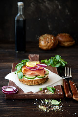 Salmon sandwich on wholewheat bread with vegetables and salad
