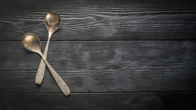 Cutlery: silver spoons on dark boards with copy space.