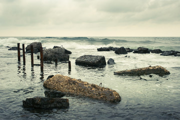 Rusty pipes and concrete slabs lying in the sea.