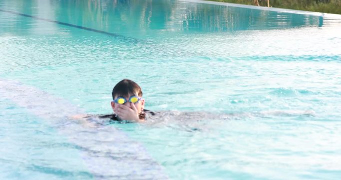 Asian boy swimming in a pool
