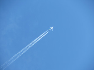 Jet airplane with contrail. Trace of the high flying plane in the blue sky 