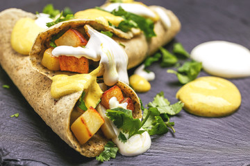 Vegetarian masala dosa with potato, chutney and sambar sauces.