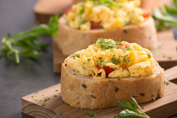 Tasty sandwich with egg and vegetables on old wood block background

