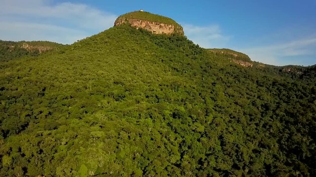 Beautiful aerial view of a mesa surrounded by dense jungle in Tocantins region of Brazil flying backwards