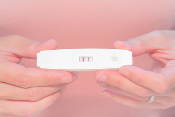 focus on the positive pregnancy test result hold on women hand