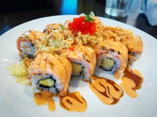 Grilled salmon sushi roll selective focus blur background