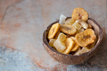 candied fruits, cashews and dried bananas in coconut shell