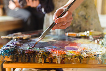 Close up of woman artist painting oils in his studio, Watercolor palette