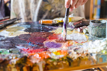 Close up of woman artist painting oils in his studio, Watercolor palette