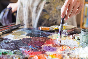 Obraz premium Close up of woman artist painting oils in his studio, Watercolor palette