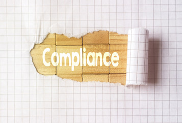 Paper tear on cube wood background with compliance text