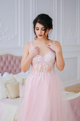 Fototapeta premium A young girl in a holiday on March 8, dressed in a luxurious pink dress