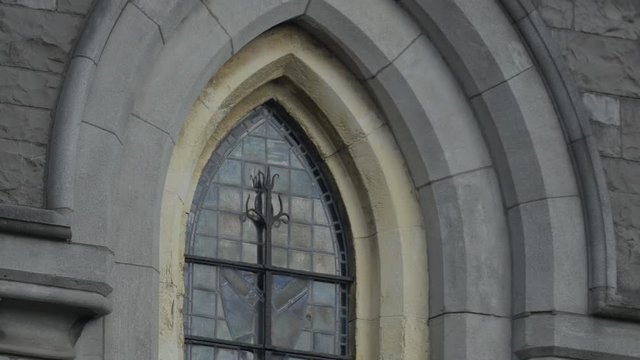 The stained glass window of a stone building