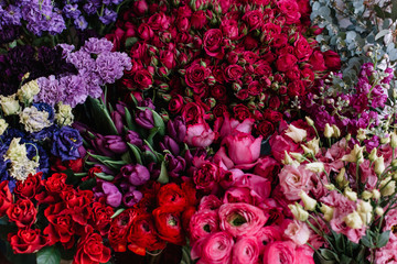 Bunch of fresh blossoming flowers at the florist shop: roses, ranunculus, tulips, eucalyptus, eustoma, mattiolas and carnations in lavender purple and red colors