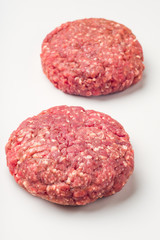 Two hamburger patties isolated on white background