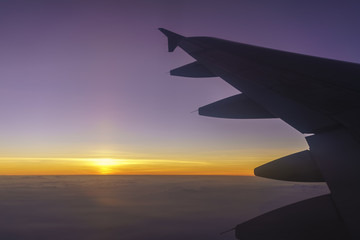 Scenery from airplane 's window viewing wing of airplane and beautiful sunset