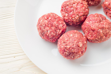Meat balls from raw beef force-meat on a white plate