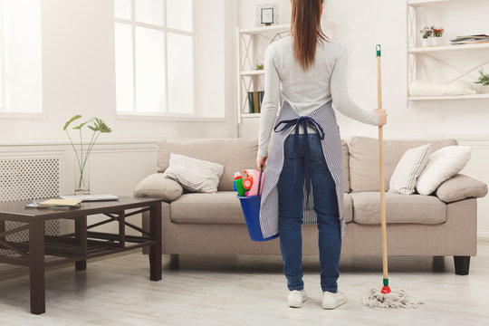 Woman with cleaning equipment ready to clean room