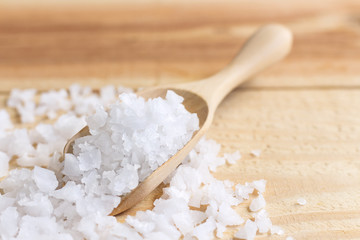 Sea salt in a wooden spoon on the table. selective focus.