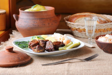 Fried meat with boiled potatoes and pickles. 