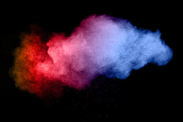 Naklejka na ściany i meble Abstract multicolored powder explosion on black background. Freeze motion of color dust particles splash. Painted Holi.