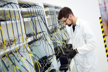 Picture of network technician testing modems in factory
