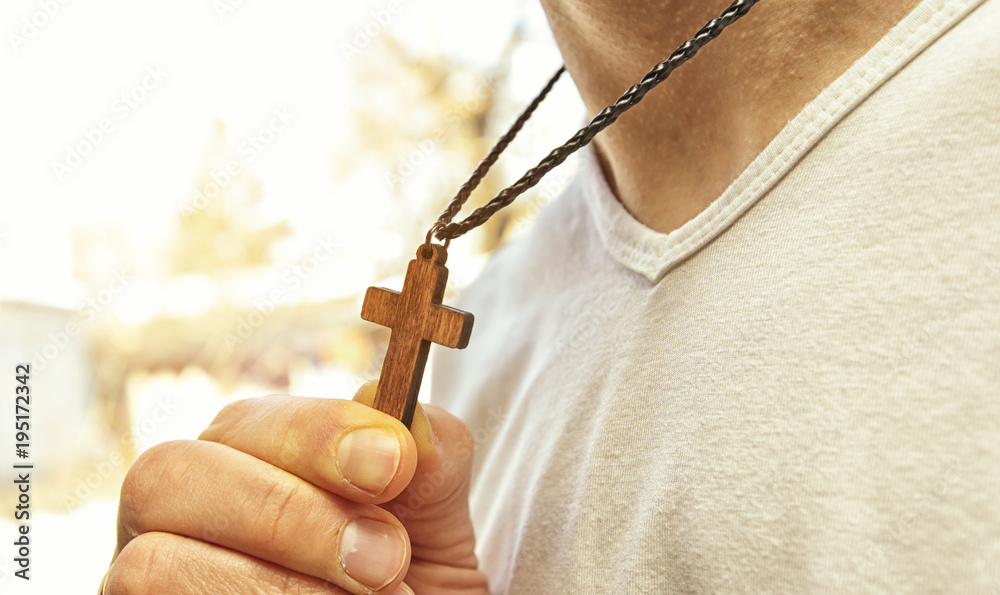 Wall mural The wooden cross necklace on man's neck