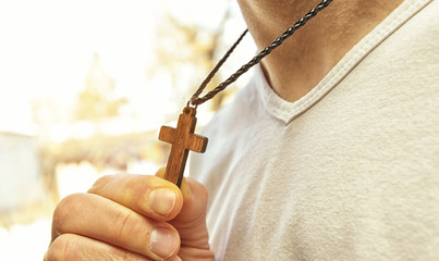 The wooden cross necklace on man's neck