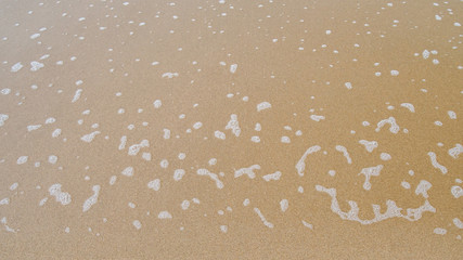 Sea foam on sand background