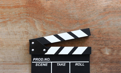 Obraz premium closeup movie clapper board on wood table with soft-focus and over light in the background