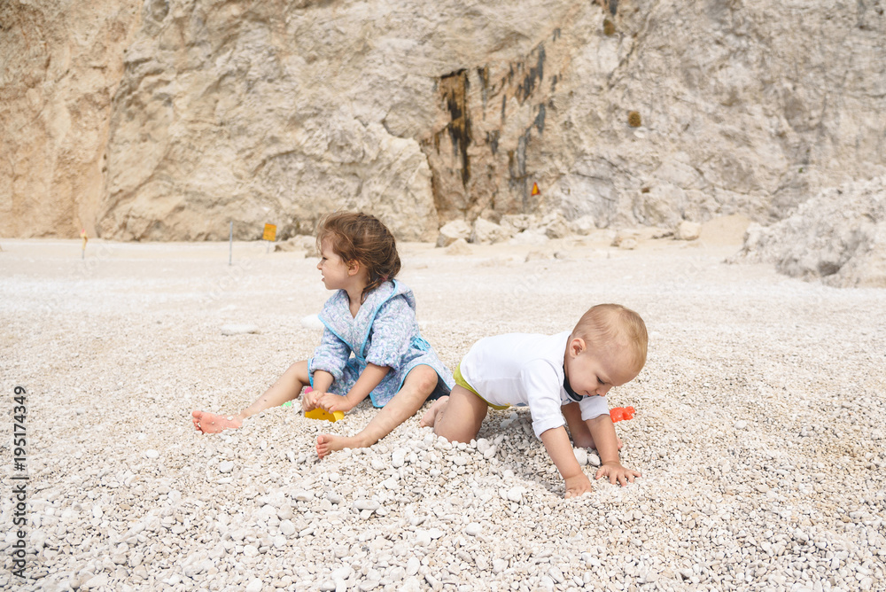 Wall mural Sister and Brother Playing with Stones