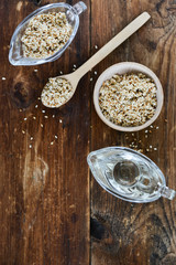 sesame seed oil and sesame seed oil in glass Cup on natural wooden background, healthy food concept, organic food.